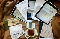 Vintage letters and hand draw sketches, postcards, ribbon, photocopied documents and a cup of tea, more codes and ciphers