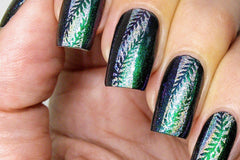 Nails with stamping nail art. Green nails with stripe of holographic silver polish down the middle and green foilage stamped.