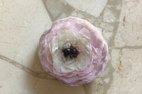 We hand make magnets that are made with whole preserved flowers cast in resin. The one featured in the image are of a preserved Ranunculus.