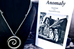A short story titled Anomaly with a run-down farmhouse on the cover. There is also an adjustable length necklace with a metal swirl pendant.