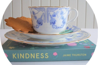 the image shows a blue and white antique cup, saucer and plate. Also a book entitled Kindness by Jaime Thurston