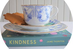 the image shows a blue and white antique cup, saucer and plate. Also a book entitled Kindness by Jaime Thurston