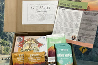 Getaway game night box with camping with sasquatch card game, single serve coffee in a bag, Bar-D hand wipes and body wipes, a sticker