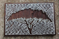 String art of a bare acacia tree on a dark wood board featured in the Craftsman Crate subscription box for hands-on crafts and skills