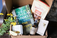 A red mug filled with three packets of Moonstruck milk chocolate, featured in the Peace & Pages monthly subscription box