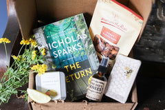 A red mug filled with three packets of Moonstruck milk chocolate, featured in the Peace & Pages monthly subscription box