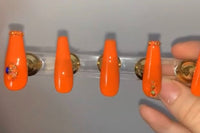 Set name: Orange Crush. Bright orange base with orange and blue rhinestones on thumb and ring tip and in the middle.