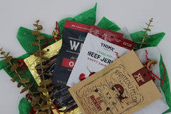 Righteous Felon, Think Sweet Chipotle, Werner Original, and Brandt Western jerky bags.  Spread out across Christmas tissue paper. 