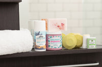 Bathroom shelf featuring Bath Bevy body lotion, bar soap, and shower steamers, ideal for self care or gifts for women