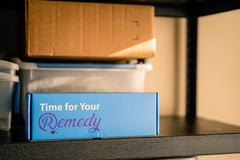 Remedy shipping/storage box is shown on shelf in garage. Box reads "Time for your Remedy." Box and sprayer are kept for future applications.