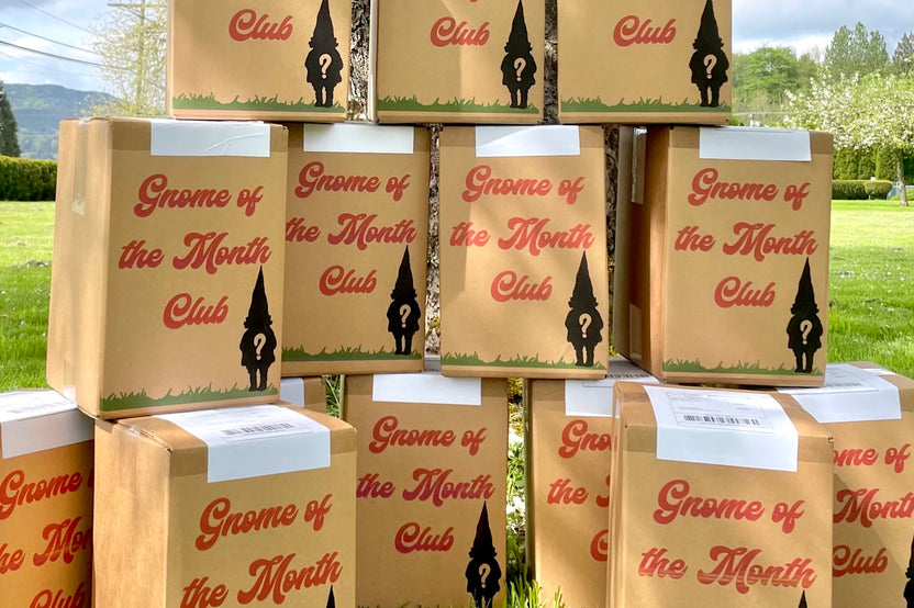 Gnome of the Month Club subscription box displayed on a front porch surrounded by neatly trimmed bushes