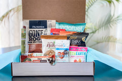 Box filled with snacks such as vidafuel, gone rogue, yumearth, back to nature, envirokids, pita thins and almonds