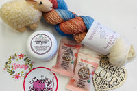 Yarn Shop Mystery Box featuring three skeins of Frog Tree Alpaca Sport yarn in green, navy, and teal with craft accessories