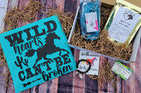 The Stable Box Subscription - wild heart horse graphic tee, horse treats, turquoise saddle pad cover, vinyl sticker and bracelet.