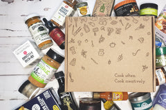 A Culinarie LUXE box surrounded by cooking ingredients. The box is decorated with illustrations of ingredients and cooking utensils.