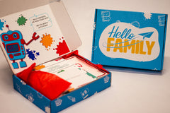 Open Hello Family kit featuring Doughbot's Creation Lab with colorful red tissue paper and additional closed Hello Family Box.