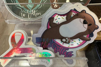 Example stickers with holographic whatever color, cancer sucks and vaporwave I’m not like the otters stickers.
