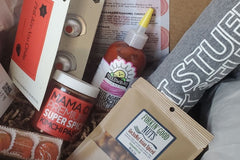 Box filled with Asian inspired spicy food items from all over the US. Includes sriracha hot sauce, gochu nuts, kimchi paste and t-shirt