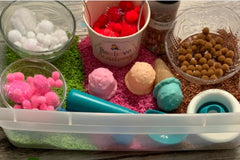 Ice Cream Sensory Kit with red, white, brown and pink pom poms. plastic ice cream scoops, ice cream cones and ice cream scoop. Colored rice
