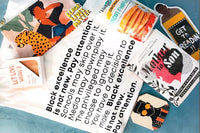 Items from a BlackLIT subscription box including soap, pancake and waffle mix, a book and bookmark and a shirt.