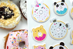 A background of delicious donuts pictured with a sheet of puffy donut stickers.  Each sticker is shaped like an animal with sprinkles.