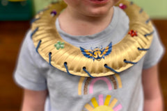 Child wearing an Egyptian necklace that she created using the Wiggle Worms-Around the World Kit-Egypt.