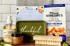 Items from an Étoile subscription box including a jar of cinnamon honey, liquid hand soap, cheese straws, and a recipe card.