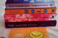 Brown subscription box filled with four light reading books, featuring charming stories and uplifting themes for easygoing book lovers.