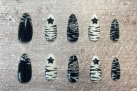 Set: Zebra'd. Black and white alternating zebra inspired set. Zebra french tip on thumbs. Black star gems on index/ring. Zebra hearts on mid