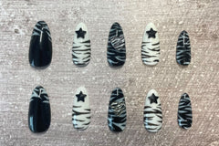 Set: Zebra'd. Black and white alternating zebra inspired set. Zebra french tip on thumbs. Black star gems on index/ring. Zebra hearts on mid