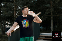 A young man taking a break from an outdoor activity and drinking water. He is wearing and Avengers shirt featuring the 4 main characters. 