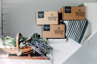 3 Appalachian Mercantile boxes on a staircase with a large basket with flowers and plants in it.
