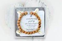 Wooden Diffuser Bracelet with Four Puka Shell Charms in White Gift Box with Aromatherapy Instruction Card.