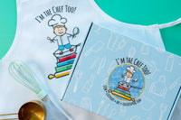 Two children engaged in the I'm The Chef Too! cooking kit, creating galaxy donuts with colorful icing and sprinkles