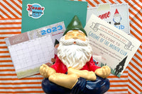 Gnome of the Month Club subscription box displayed on a front porch surrounded by neatly trimmed bushes