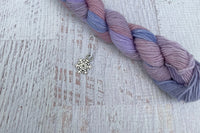 A mini Skein of Hand Dyed Merino Sock Weight Yarn and a coordinating stitch marker. Suitable for knitting and crocheting 