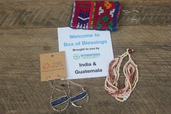 India and Guatemala Box of Blessings featuring silver and blue earrings, a 12 strand beaded bracelet, and a huipile keychain.