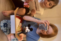 Two little girls joyfully explore items from their subscription box, including a facial soap and a hygiene tip!