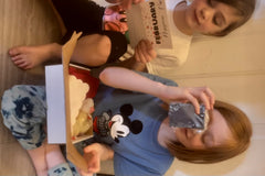 Two little girls joyfully explore items from their subscription box, including a facial soap and a hygiene tip!