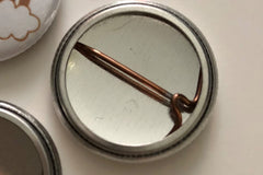 Buttons come with a pin in the back. Pins may be easily removed to wear buttons on magnetic accessories bases.