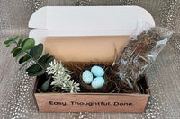 Entry Envy April Refill Decor Kit- pictured: green and white floral pick, moss bag with metal sticks to secure moss, nest with eggs on pick.