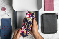 A SprezzaBox monthly subscription box featuring a watch, tie, socks, and a wooden comb for men's accessories