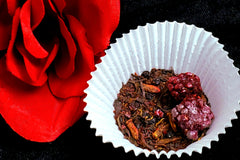 A shot of my Fruitful Foraging tea in loose leaf form to the right posed next to a red rose on the left.