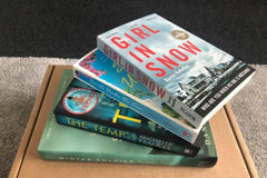 Brown subscription box filled with four surprise mystery books, featuring captivating stories and intriguing plots for genre enthusiasts.