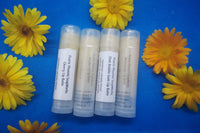 4 Natural, homemade lip balms  Raspberry, Watermelon, Pink Bubblegum and Cherry flavours. Surrounded by calendula flowers 