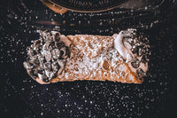 Our signature cannoli are an authentic Italian pastry filled with a light cream.  They come in a variety of flavors and unlimited toppings.