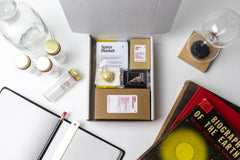 An open box displaying a selection of items that have been featured in past Matter boxes, featuring a space blanket