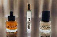 LOKA.HAUS: 'Duality Oil' in amber, center 'Intensity Parfum Roller' & right, 'Radiant Serum'. Elegance & quality shine in every drop.