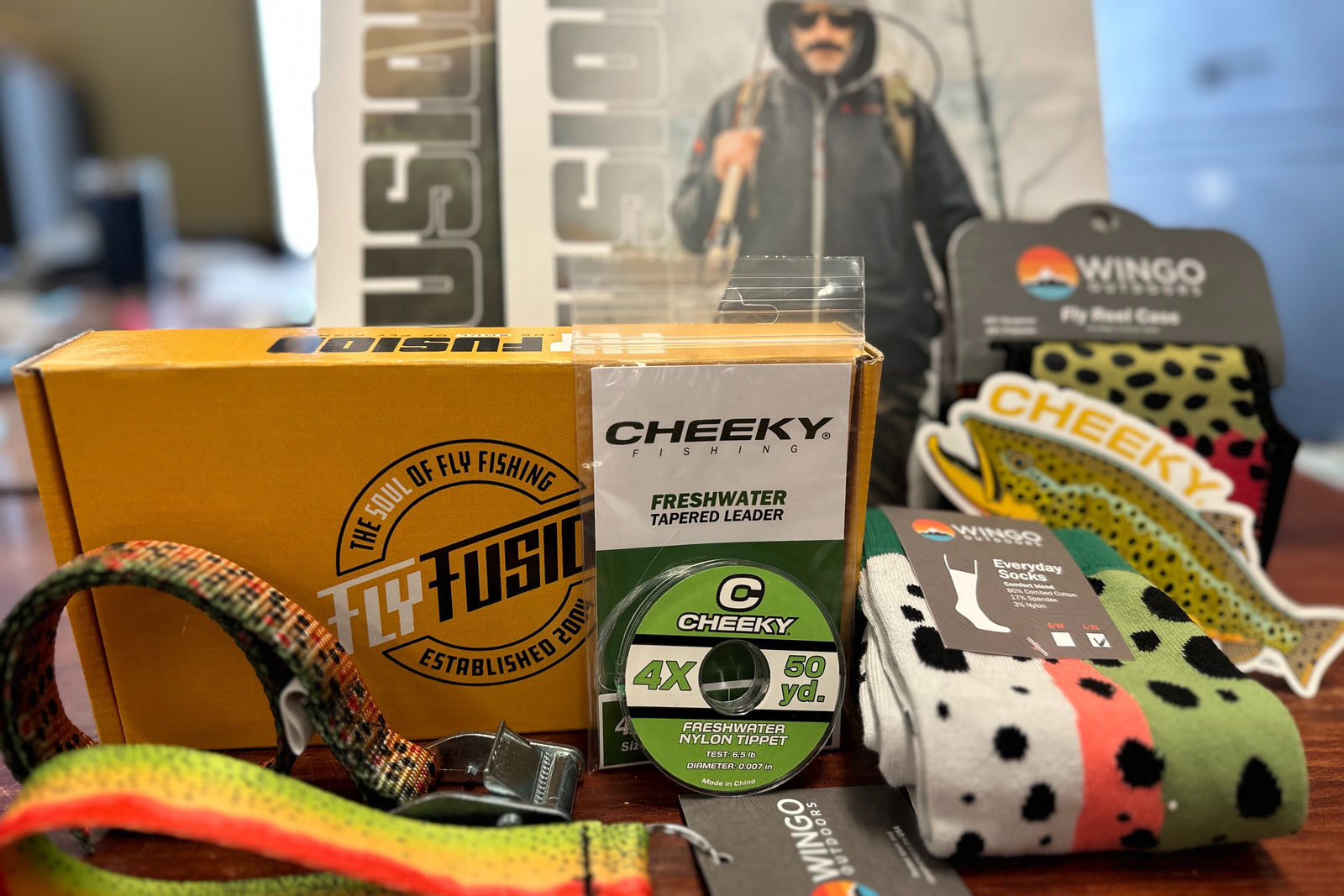 Fall 2023 Gear Box includes Cheeky Leader and Tippet, Wingo Socks, Reel case, Cam Strap and Key Fob, 2 issue of Fly Fusion and MORE!