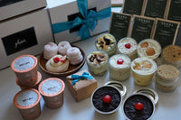 Phivi subscription boxes stacked with a variety of desserts in front, including cookies, meringue and others.